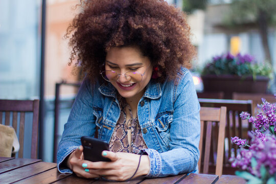 Chica sonriente  mirando su telefono celular 