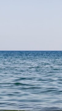 Public beach, summer, beautiful sunny weather. Picturesque beach, waves crashing on the sandy shore.