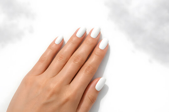 Close-Up of Elegant Female Hand with White Oval Gel Nails on Soft White Fabric Background for Nail Beauty Concept