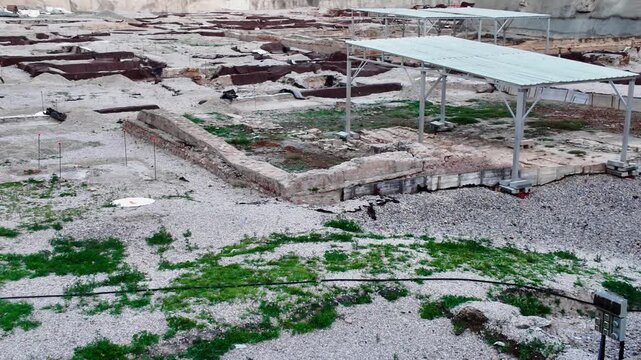 archaeological site of san esteban in murcia spain featuring ancient ruins excavation structures stone walls historical foundations metal protective covers green grass and dirt ground in urban setting