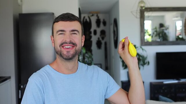 Man watching inflated balloon deflate suddenly and smiling with great relief