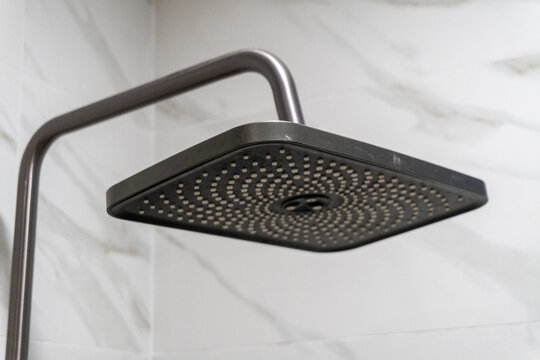 Closeup of black showerhead in modern bathroom