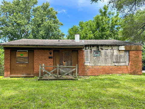 Dilapidated house with boarded-up doors and windows in the South Suburbs of Chicago, IL USA