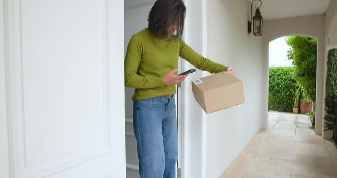 Woman on porch seeing box picking it, checking phone for delivery, returning, copy space