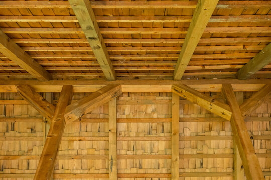 Rustic wooden ceiling with exposed beams and intricate latticework.