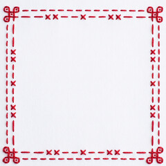Fototapeta premium Cross-stitch pattern in vibrant red thread creates a geometric square border on white material providing a decorative frame that allows for easy insertion of text or graphics in the middle.