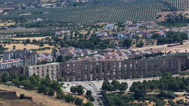 Cinematic drone view of historic Elvas aqueduct and fortress city with traditional white buildings and ancient stone walls in Portugal's scenic Alentejo region