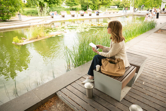 Mature business woman using a tablet while enjoying a quiet break in a city park