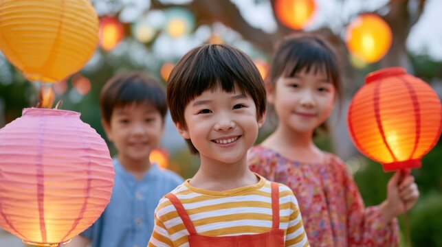 Children holding colorful lanterns in a garden during a festive evening, with illuminated decorations creating a vibrant atmosphere around them