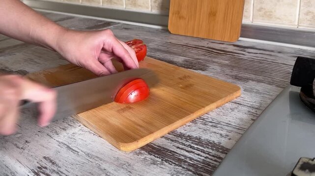 Slicing Red Tomato on Cutting Board