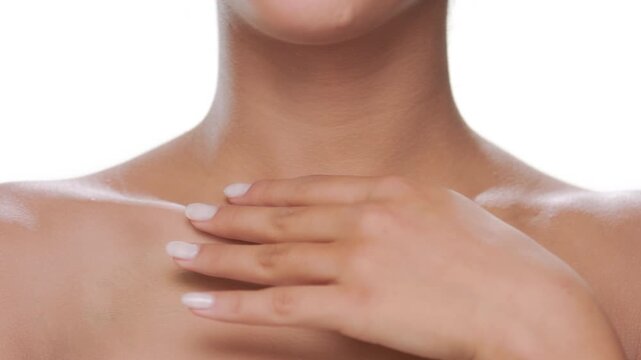 Big closeup of cosmetic model gently stroking her clavicles presenting moisturized skin on white background | Moisturizing product commercial