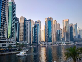 Fototapeta premium Rascacielos residenciales modernos en Dubái Marina al atardecer con yate navegando