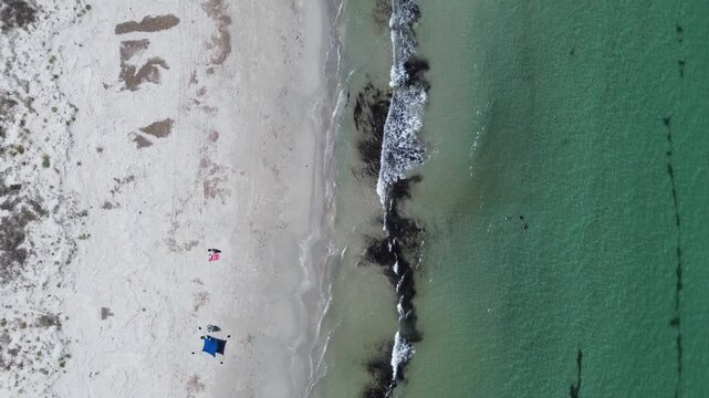 aerial view of Playa de la Llana beach in San Pedro del Pinatar Spain featuring pristine white sand turquoise sea water people swimming and small colorful beach equipment setup