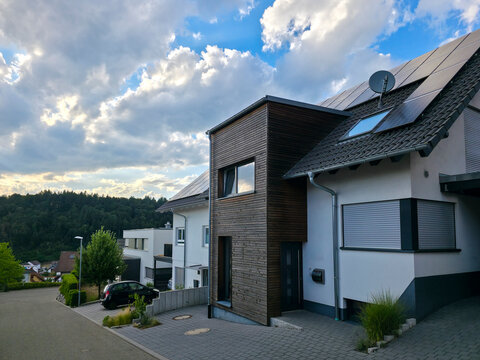 germany, beautiful newly built houses in elzach black forest village glowing beneath breathtaking summer sunset with peaceful countryside charm and vibrant sky