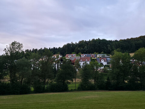 germany, breathtaking sunset panorama of elzach black forest village rising from peaceful valley beneath radiant orange summer evening sky