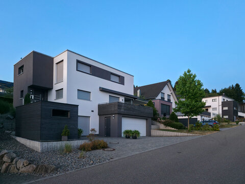 germany, inviting sunset through sonnensiedlung residential street showcasing contemporary elzach homes beneath brilliant summer blue sky within the scenic schwarzwald region