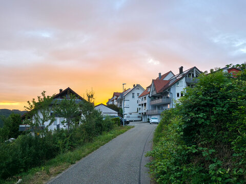 germany, scenic country road leading toward charming elzach black forest village beneath glowing orange sunset and magnificent summer evening sky