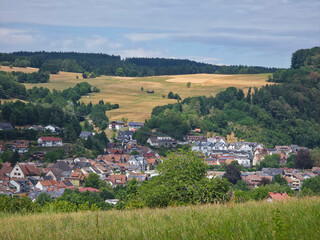 Fototapeta premium germany, sweeping panorama above elzach black forest village overlooking peaceful valley beneath glowing sunset and vibrant colorful summer evening horizon