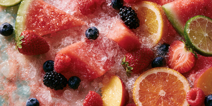 Sliced watermelon berries and citrus fruits arranged on crushed ice vibrant food photography blueberries strawberries