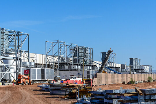 Large hyperscale data center campus under construction with exposed steel framing, prefabricated equipment modules, and active building assembly, representing digital infrastructure growth and cloud