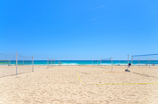 Playa de San Juan beach in Alicante city, sports volleyball courts with volleyball net on sandy beach of Mediterranean Sea coast Costa Blanca coastline in sunny summer day, Valencian Community, Spain