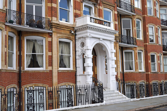 White portico entrance to red brick apartment building in London
