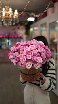 A large bouquet of delicate pink bush roses in a gift box. Floral arrangement concept.