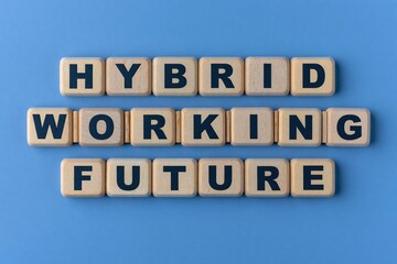 Fototapeta premium Hybrid working future written on wooden blocks on blue background