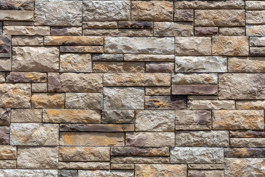 Full frame abstract texture background of a of a ledgerstone style brick wall, with natural stone in different shapes and sizes