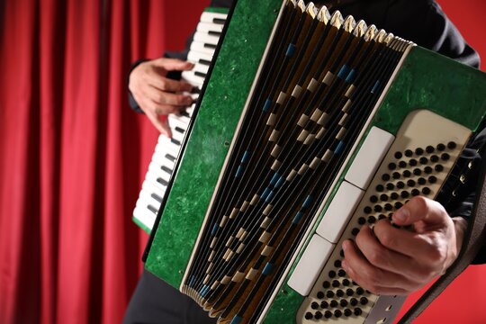 Man playing piano accordion on stage, closeup