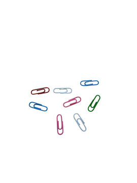 Colorful paper clips scattered on a flat surface