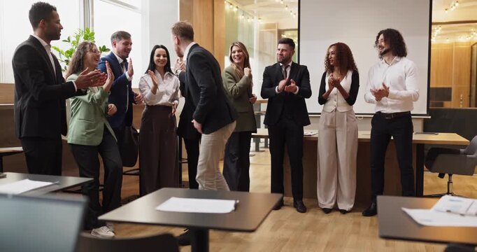 Business team people celebrate success at office. Colleagues applaud a coworker for achievement. Diverse professionals show unity, motivation and optimism. Clear concept of team success.