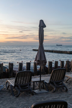 Beach loungers with umbrella at sunset by the Baltic Sea in Svetlogorsk