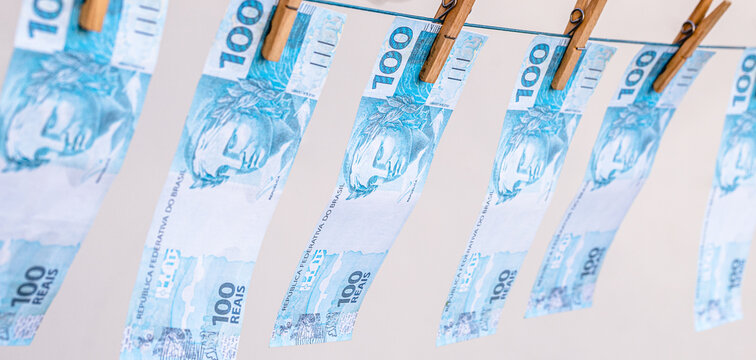 Money laundering concept featuring Brazilian banknotes hanging on a clothesline; corruption, financial scandal, theft.