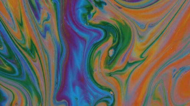 Macro shot of iridescent soap film interference patterns swirling in royal blue and burnt orange
