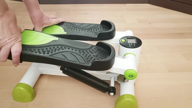 Person using mini stepper at home showing proper form and technique, lifestyle fitness content demonstrating real-world application.