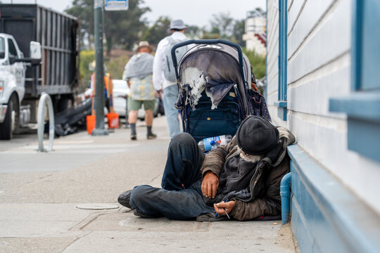 San Francisco, USA - September 10, 2025: Homeless person resting on a sidewalk near Fisherman's Wharf. A glimpse into the social realities that contrast with the tourist area.