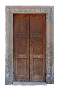  Old traditional European entrance featuring weathered brown wooden double doors with rectangular panels and a vintage metal handle, framed by a classic rustic grey stone portal and threshold