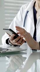 Fototapeta premium Medical professional using smartphone and laptop, checking health data, consulting information, and managing patient records with healthcare technology
