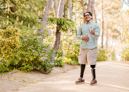 Latino man with prosthetic legs smiling outdoors