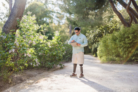 Latino man with prosthetic legs working in park