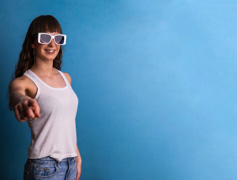 Young woman pointing at camera wearing sunglasses