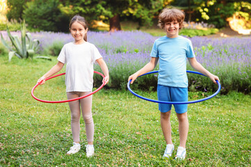 Cute kids exercising with hula hoops in park © New Africa