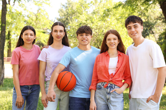 Group of teenagers with basketball ball in park