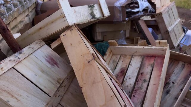 Pile of discarded wooden crates and boxes with cardboard, recycling and waste management. Industry, environment, outdoors