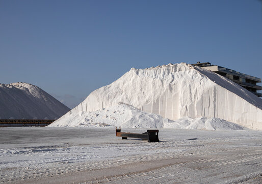Gigantic industrial mounds of white sea salt at saline factory in Santa Pola, Spain during daylight hours