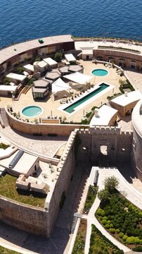 Vertical Drone Shot of Swimming Pools, Parasols and Walls on Mamula Island, Former Fortress in Adriatic Sea, Montenegro