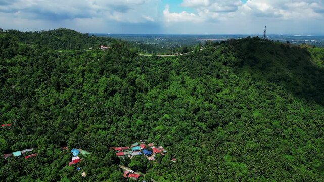 Pullback drone reveal of People's Park in the Sky highlighting mountain terrain, scenic roads, tropical forests, and panoramic natural landscapes in Tagaytay City Cavite Philippines.