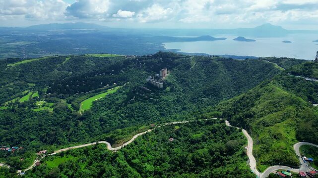 Smooth forward drone flight showcasing Woodridge Place revealing panoramic mountain scenery leading toward People's Park in the Sky with Taal Volcano dominating the horizon as backdrop.