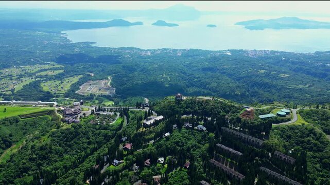 Pullback aerial reveal emphasizing the elevated landscape of Tagaytay Highlands with luxury accommodations, mountain roads, and one of the Philippines' most recognizable volcanic landscapes.